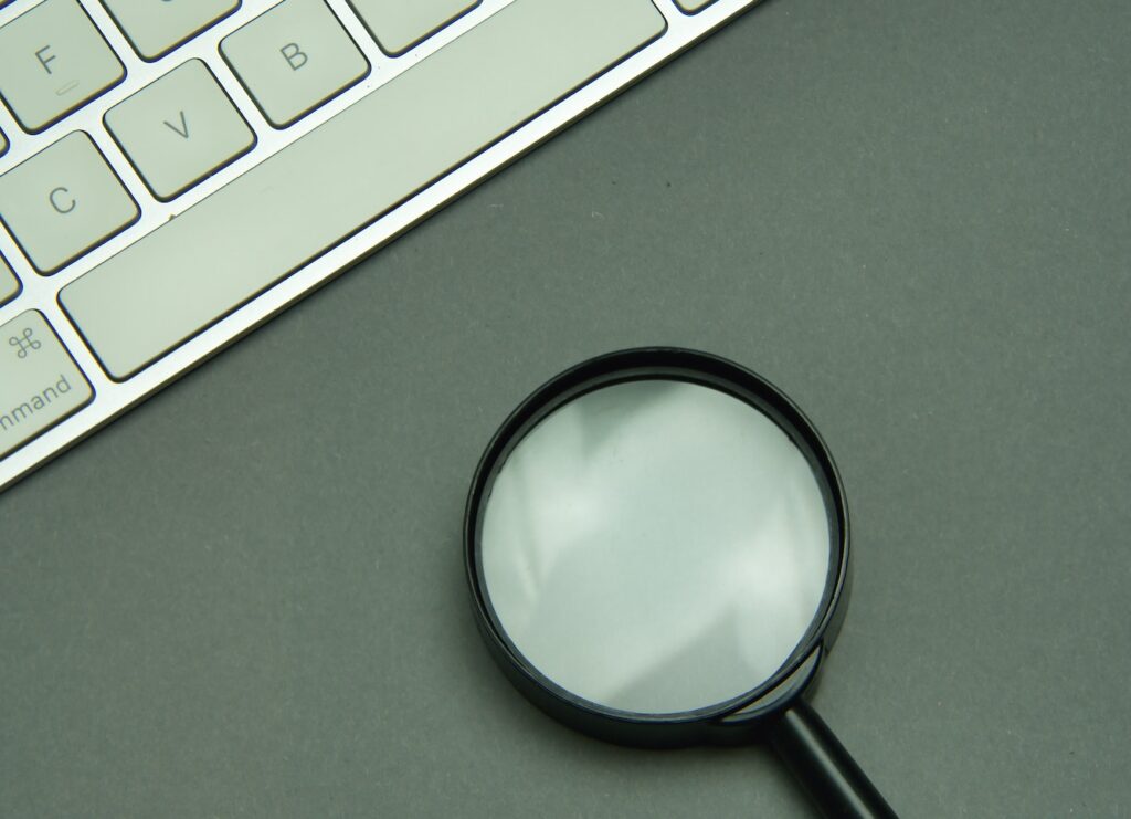 Magnifying glass and laptop keyboard. Seo.